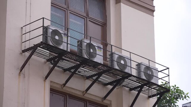 Many AC units are installed outside a building.