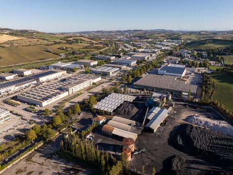 Aerial view of an industrial estate with warehouses, factory buildings, and storage yards in Ancona, Marche, Italy.