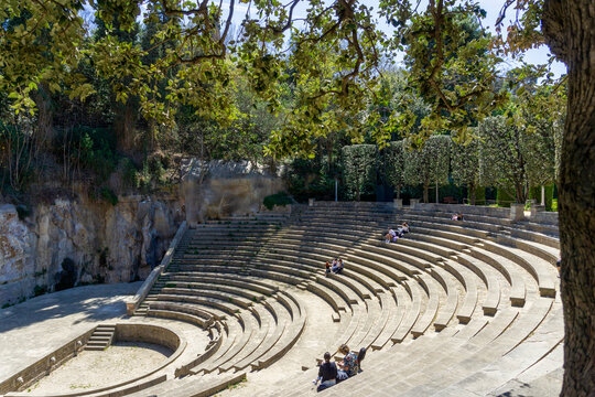 Teatre Grec, a classic Greek-style open-air amphitheater on Montju&iuml;c hill in Barcelona, Spain, featuring tiered stone seating for public performances and events, surrounded by lush green foliage