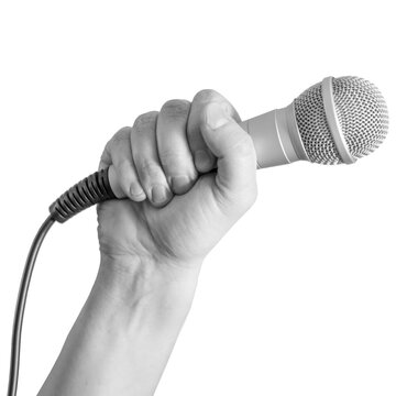 A hand grips a microphone firmly. The background is plain transparent. This scene suggests a performance, speech, or public speaking event. The focus is on the hand's position and the microphone.