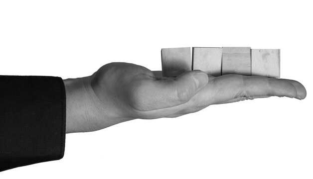 A hand is open and facing up, supporting four rectangular blocks. The blocks are arranged in a line on the palm. The background is transparent.