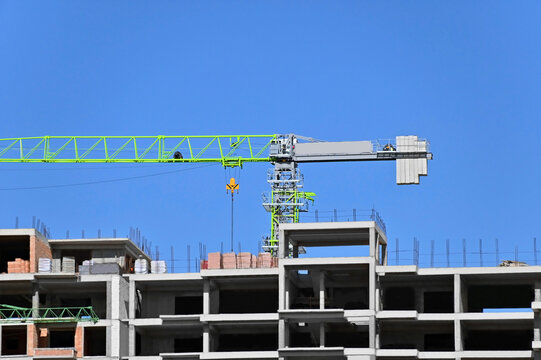 Multistory construction site with crane and blue sky