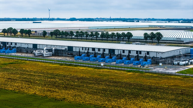Aerial view of Agriport A7 featuring large industrial facilities, rows of greenhouses, and surrounding agricultural fields in Middenmeer, Noord-Holland, Netherlands.