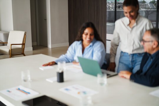Defocused multigenerational business people sharing ideas inside company office - Multiracial colleagues discussing new financial project - Main focus on chair - Trendy UGC photo