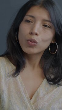 Beautiful Hispanic lady taking selfie with smartphone posing having fun on black studio background. Photo and modern lifestyle concept.
