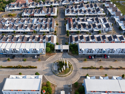 Aerial view of a modern residential housing complex with uniform white houses and a central roundabout in Semarang, Central Java, Indonesia.