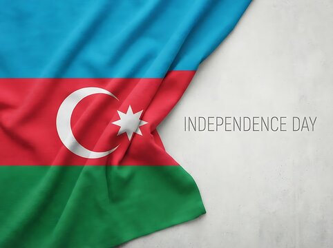Draped fabric flag of Azerbaijan with Independence Day text isolated on light grey stone surface background.