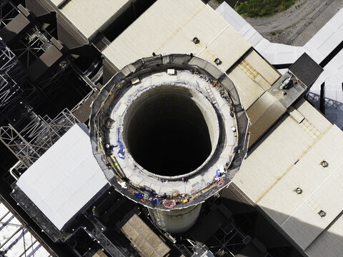 Aerial view of the exhaust stack at the Gallatin Fossil Plant, showing workers on the rim of the industrial chimney structure in Gallatin, TN, United States.