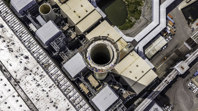 Aerial view of the exhaust stack at the fossil fuel power plant with industrial rooftops and infrastructure in Gallatin, TN, United States.