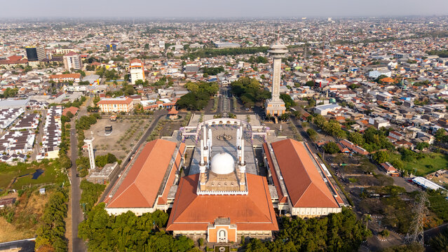 Aerial view of Masjid Agung Jawa Tengah with its large dome, tall minarets, and courtyard, surrounded by the urban landscape of Kecamatan Gayamsari, Jawa Tengah, Indonesia.