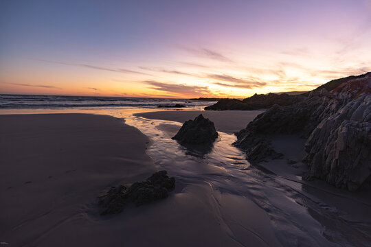 sunset and dusk descending upon the iconic rock formations of Grotto and Voelklip Beaches, Hermanus, South Africa
