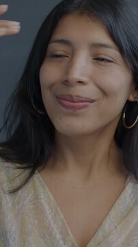 Slow motion portrait of creative Hispanic lady dancing moving hands looking at camera on black background. People and party concept.