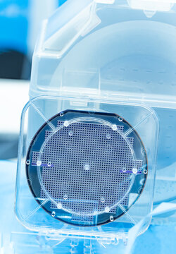 Silicon Wafers in plastic holder box for manufacturing semiconductor of integrated circuit.Electronic circuit designs have been built onto the wafers using micromaching including photolithography
