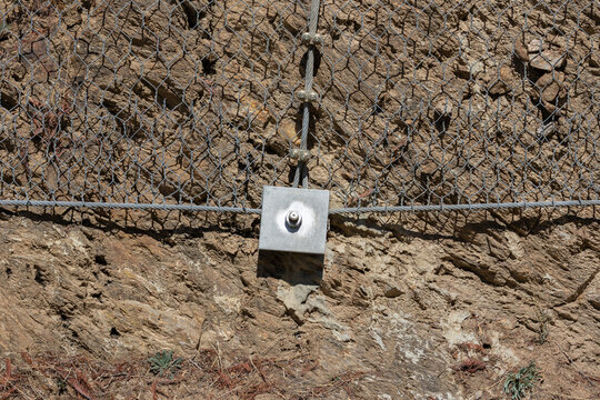 Rockfall protection net stabilizing mountain slope