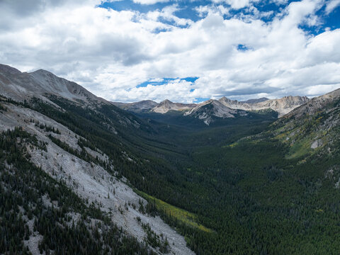 Aerial view of Mount Harvard rising above a dense pine forest and a rugged mountain valley in Buena Vista, Colorado, United States.