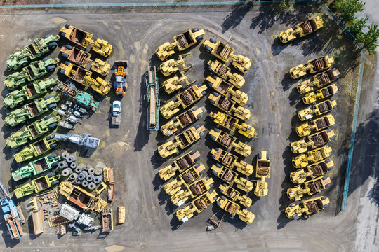 Aerial view of heavy construction machinery and logging equipment parked in neat rows at a storage yard in Woodburn, Oregon, United States.