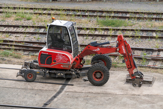 Nancy, France - August 5th 2026 : View on a red mobile walking excavator Euromach R45 on a construction site for railway works with railway lines in the background.