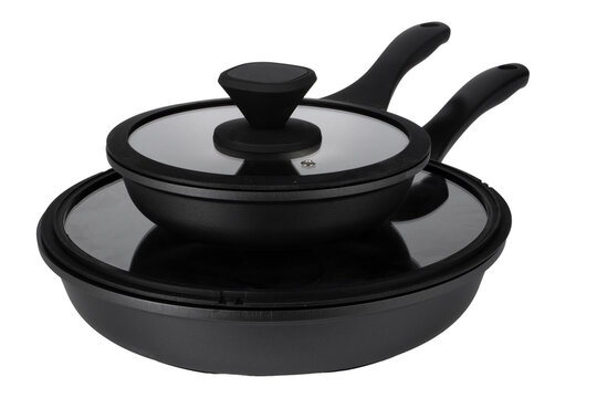 Two black frying pans stacked with a lid, ready for cooking tasks in a kitchen