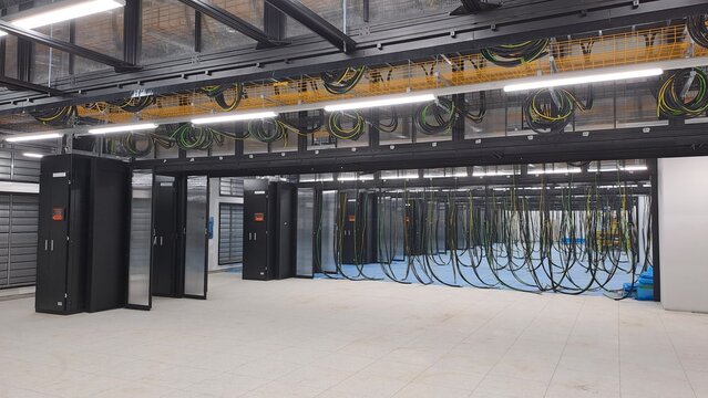 Data center computer room under construction with overhead containment, PDU cabinets and electrical cables