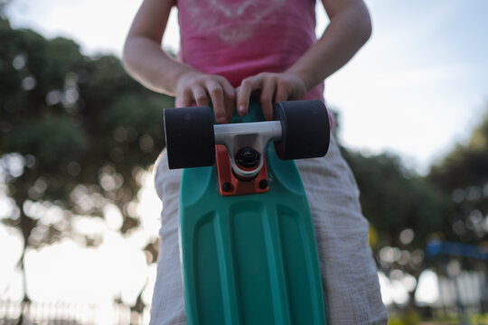 Close-up of Child Holding Mint Green Penny Board Skateboard Outdoors
