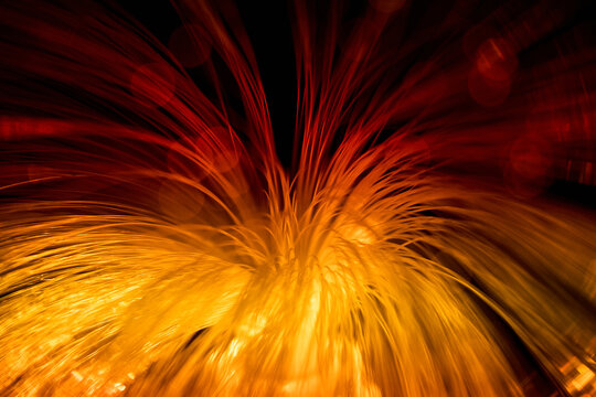 Abstract fiber optic light trails in red and gold