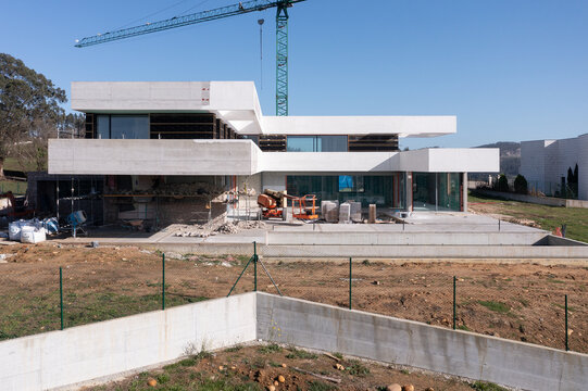 Modern house construction site with crane and concrete facade