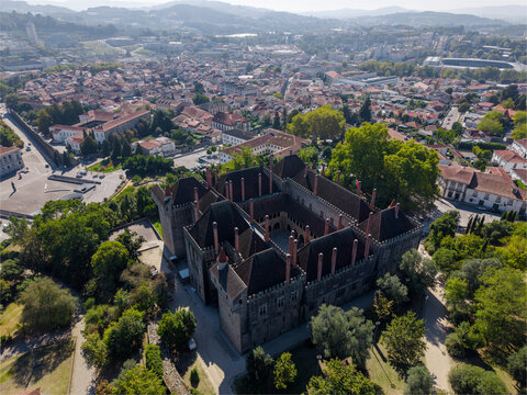 Aerial view of the historic Paco dos Duques de Braganca with its distinctive chimneys and central courtyard, set within the urban landscape of Guimaraes, Braga, Portugal.