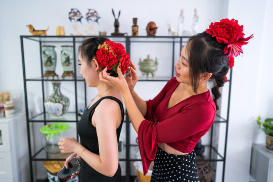 Woman adjust flower accessory for flamenco dress hairstyle