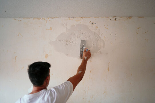 Professional painter repair wall during home renovation