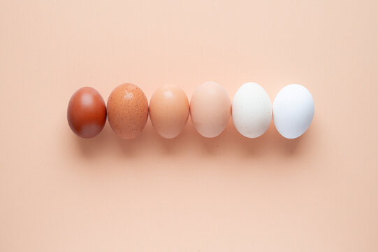 Organic natural egg assortment on a soft peach background