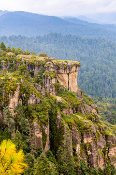Rocky cliff above forested mountain valley landscape