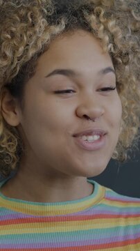 African American woman making online video call with smartphone on black background. Virtual meeting and distance communication concept.