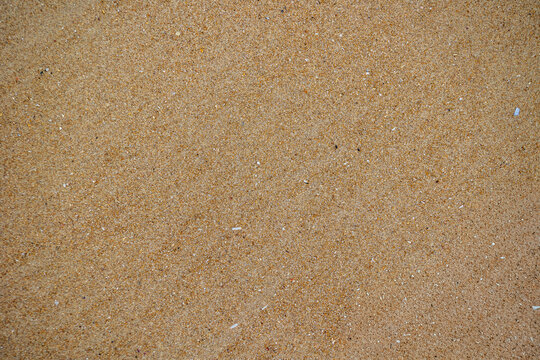 Minimal close-up of fine beige sand with delicate grains, warm earthy tones, subtle shadows, and a clean natural texture for creative backgrounds.