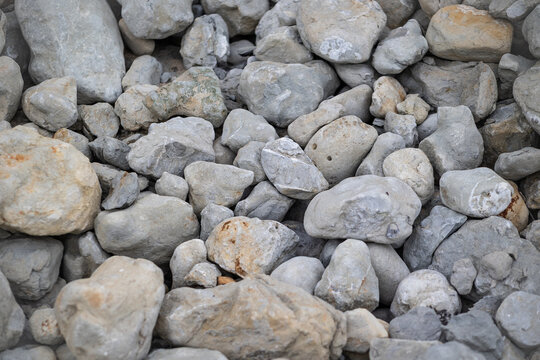 Collection of rounded gray rocks and natural stones displaying varied shapes, rough surfaces, earthy tones, and detailed geological texture.