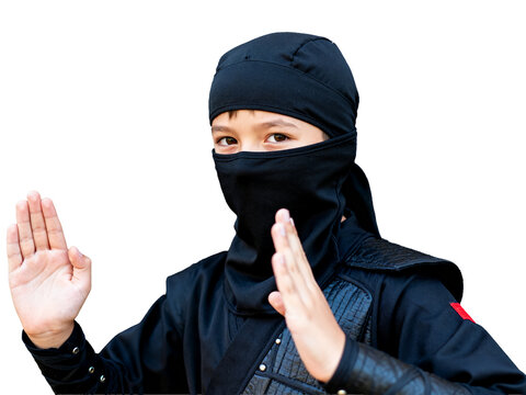 Mysterious masked ninja child, focused in a dynamic martial arts pose against a deep black backdrop, ideal for eerie Halloween promotions.