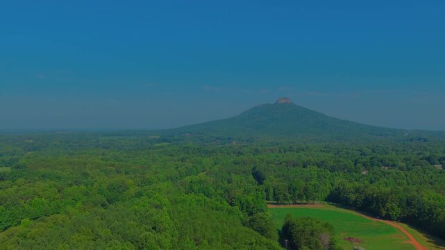 An erosion-resistant quartzite monadnock stands isolated above the eroded Piedmont plateau &mdash; a textbook example of differential weathering and landform survival.