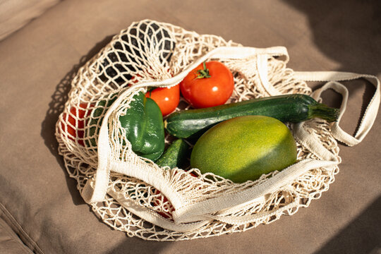 Fresh vegetable and mango in reusable mesh shopping bag