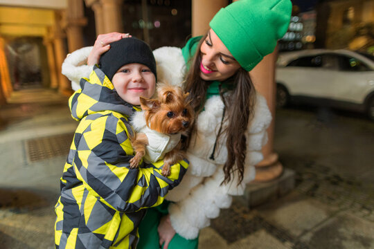 Happy mother and child with dog in city evening