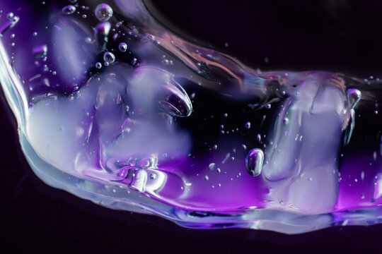 Abstract purple fluid texture with bubbles on dark background