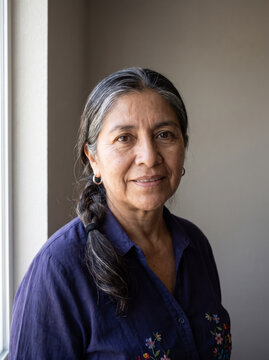 Dignified mature woman portrait with gray braid and embroidered blouse, Dia de Muertos