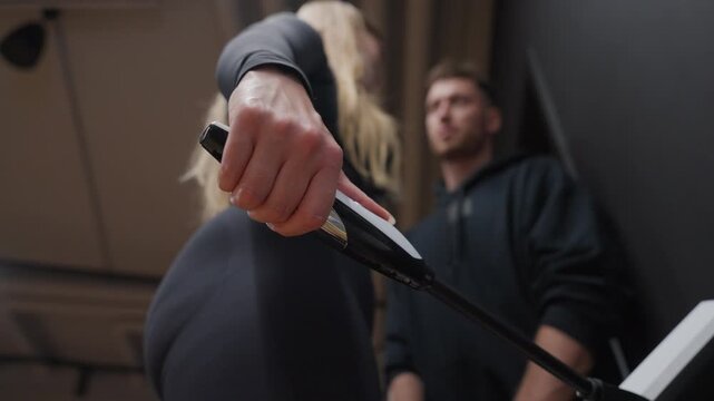 Extreme low-angle close-up focuses on a woman's hand gripping an electrode handle during a body composition test.