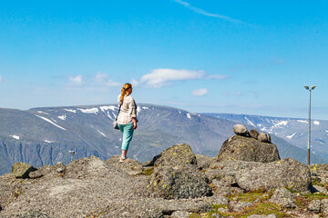 A tourist girl admires the northern mountains of Khibiny from above.  Arctic tourism. © lizavetta