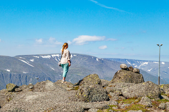 A tourist girl admires the northern mountains of Khibiny from above.  Arctic tourism.