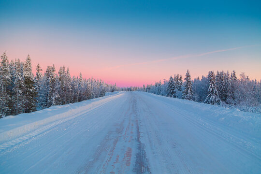 Road in the winter forest at sunset. Amazing winter landscape.