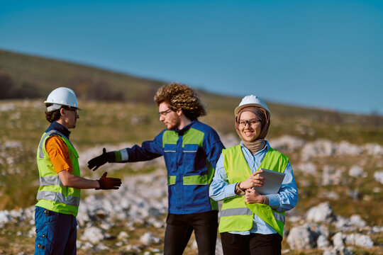 Construction Engineers Team on Rural Site With Safety Gear and Female Engineer Holding Tablet
