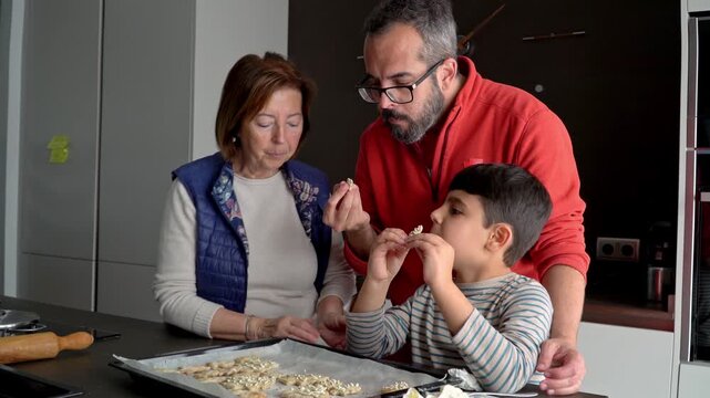 Multigenerational family tasting christmas cookies receipe on the kitchen with happiness