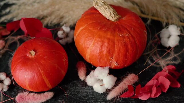 Bright orange pumpkin surrounded by autumn decorations, cotton, foliage, and rustic elements, creating a warm Halloween and fall atmosphere for seasonal, festive, and holiday content