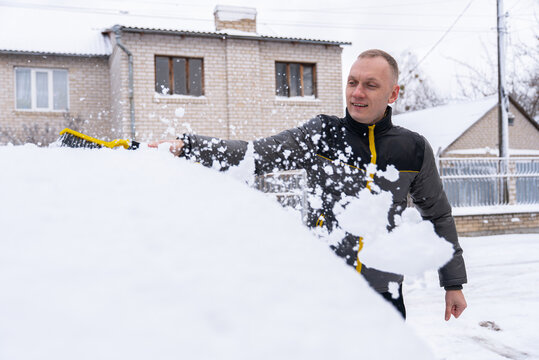 Man remove snow from car during winter weather