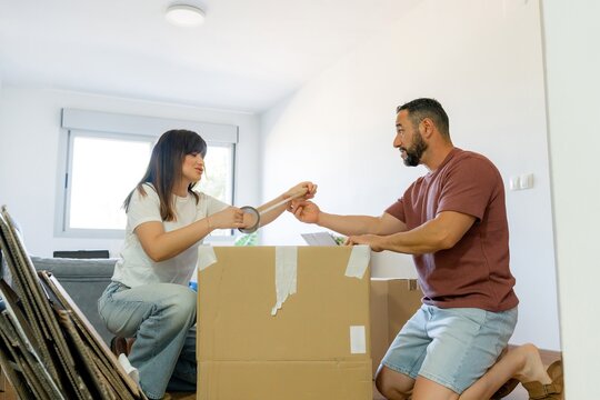 Couple pack cardboard box during home relocation