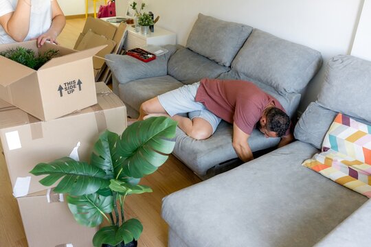 Man assemble sectional sofa in bright living room